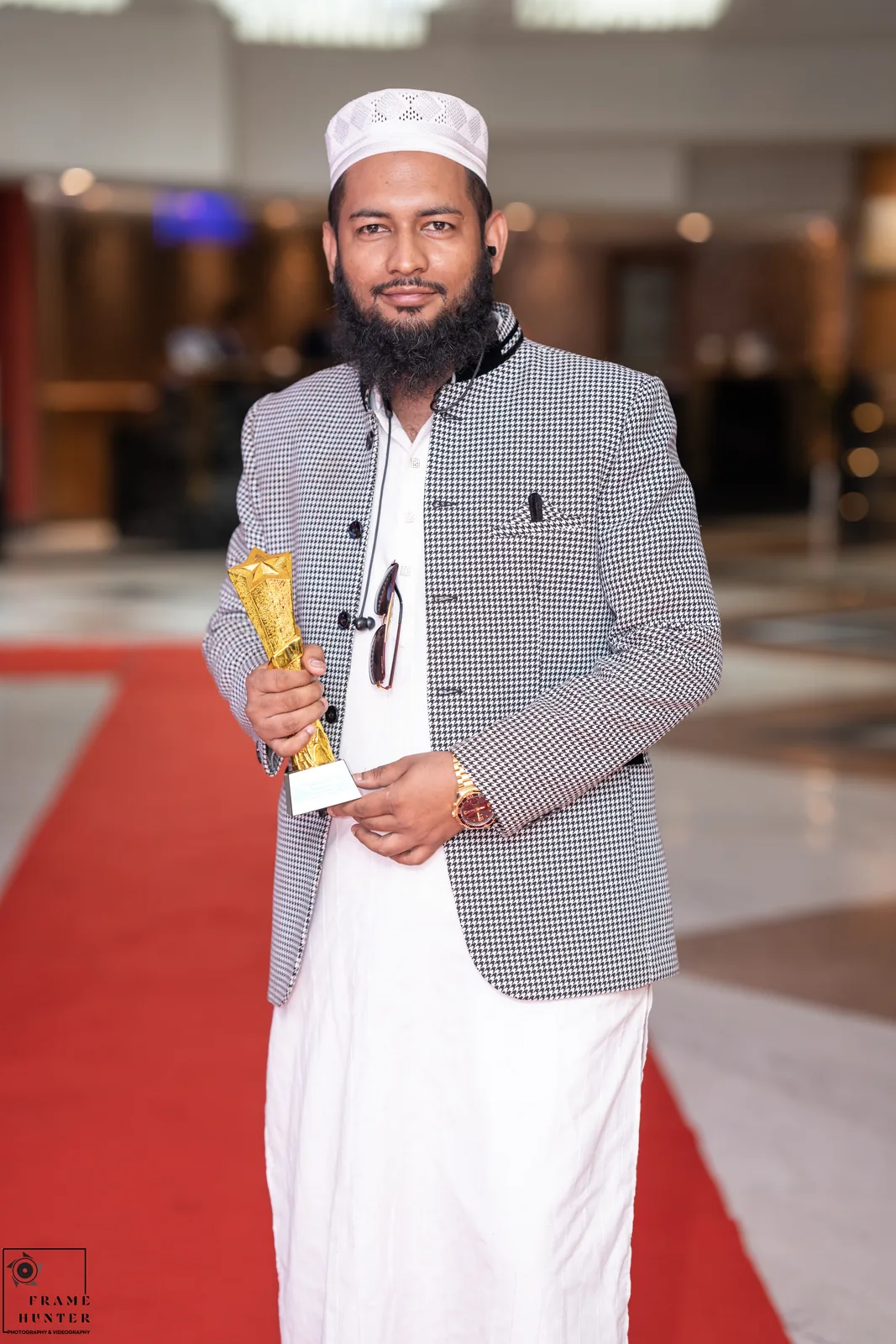 Md. Farhan Habib holding the trophy on the red carpet