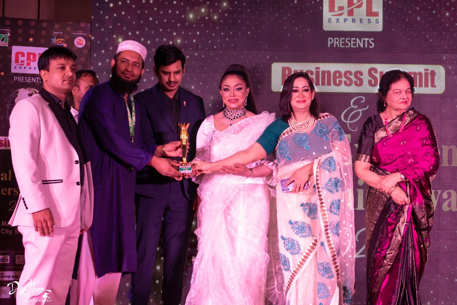 Receiving the trophy on stage at the Business Summit